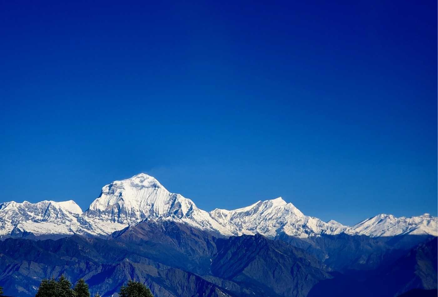 Mt. Daulagiri and Tukuche peak view from Poon Hill with white snowy mountain and blue sky.