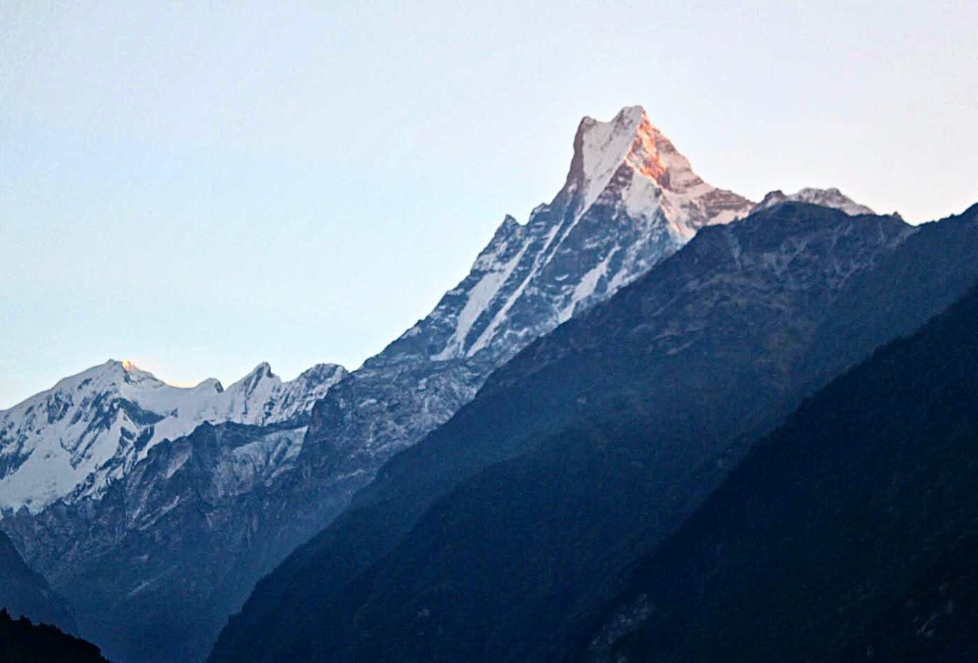 Mt. Fishtail standing tall with sunrise at top of mountain while treking to annapurna base camp. 
