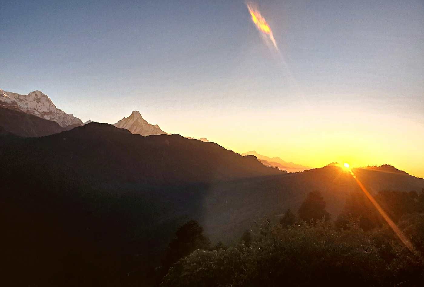 Hiunchuli and Mt. Fishtail far standing while sun rising with orange colour atmosphere from Poon Hill. 