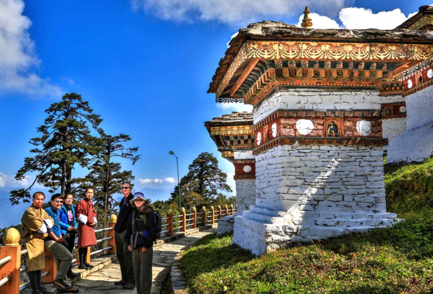 Tourist standing alongside the monuments at Dochu-La Pass in Bhutan, surrounded by the beautiful mountain scenery.