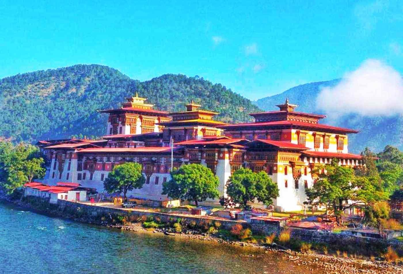 Punakha Dzong, a traditional Bhutanese fortress with a vibrant red roof, situated on the banks of the Po Chu river