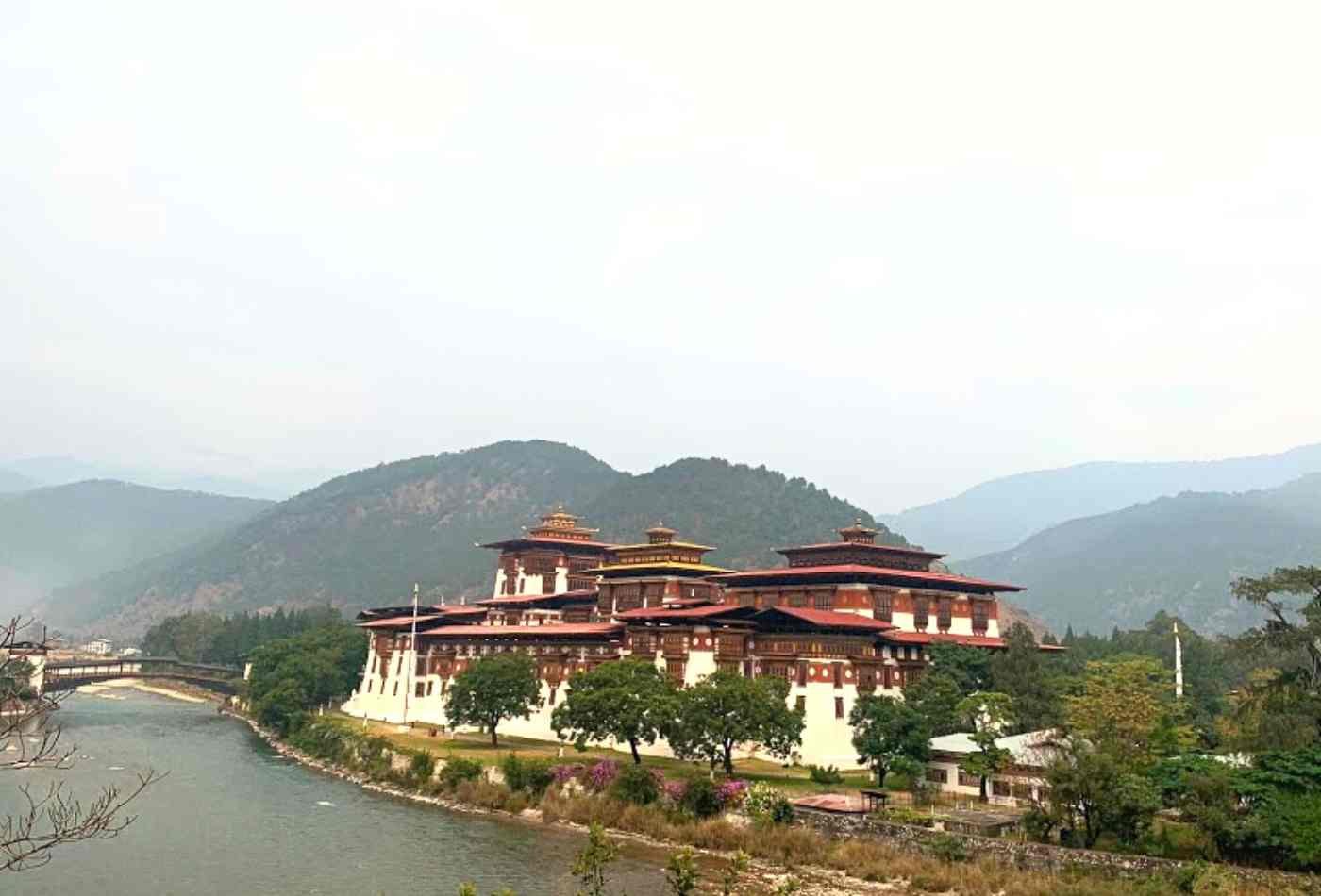 Punakha Dzong, a traditional Bhutanese fortress with a vibrant red roof, situated on the banks of the Po Chu river