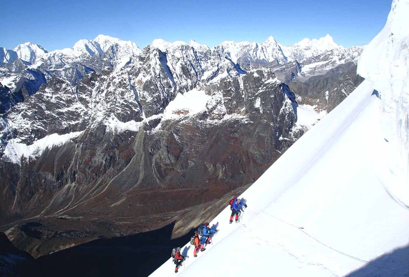 A group of determined climbers making their way up the steep slope of Labuche peak in the early morning light.