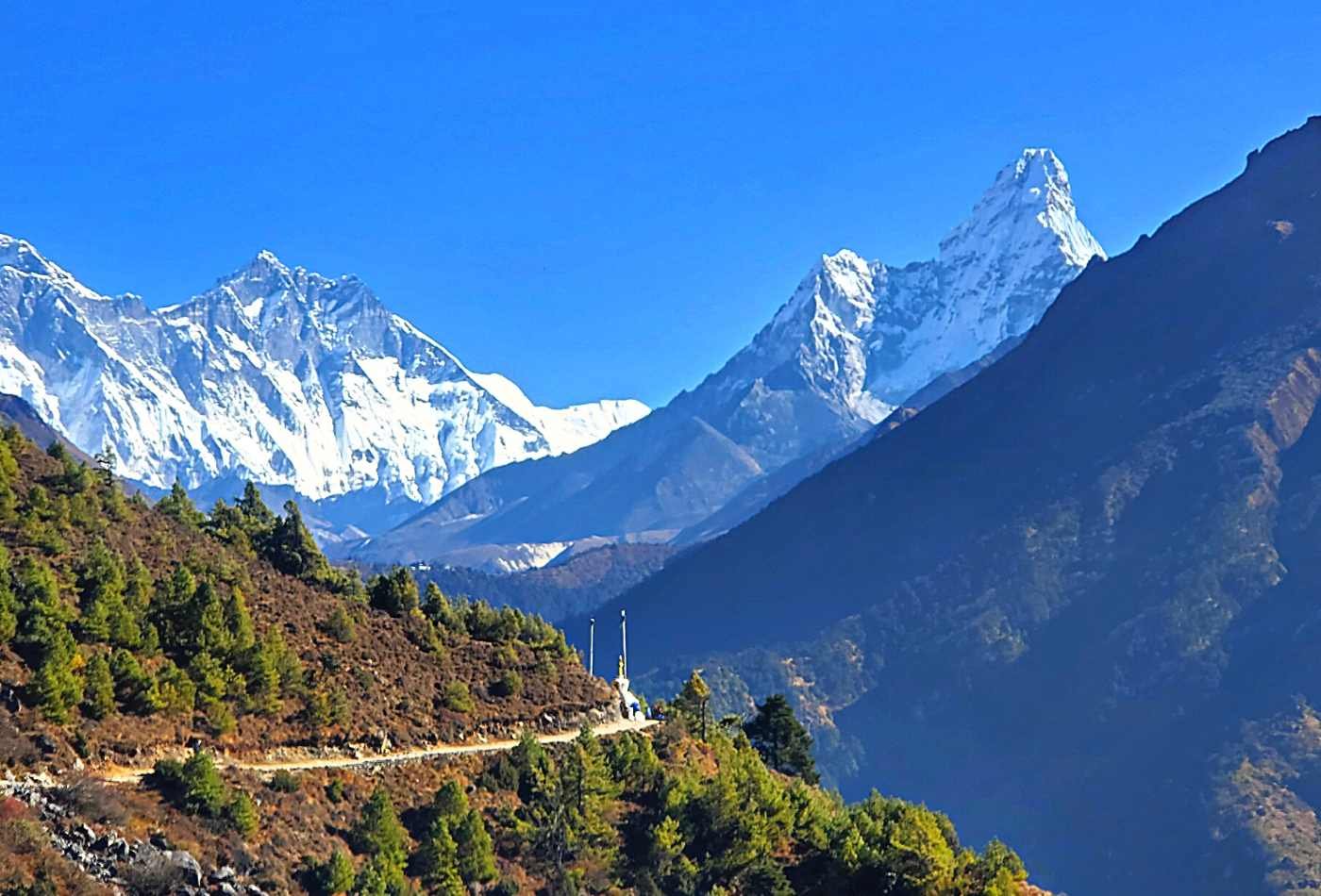View of Mt. Amadablam and Mt. Lhotse from Namche Bazaar, a picturesque mountain village, on a clear day with clear visibility of the peaks.