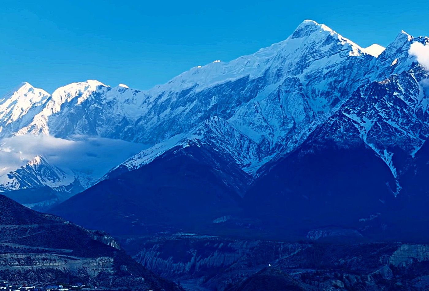 Picture of Mt. Nilgiri and Tilicho Peak covered in a blanket of snow, taken on a clear day from Jomsom, Nepal.